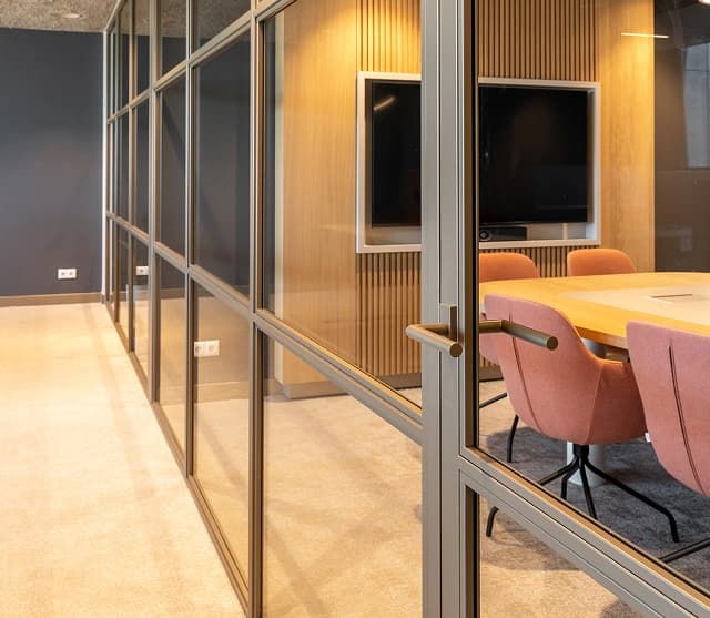 Vergaderzaal met bronskleurige stalen deuren en randen